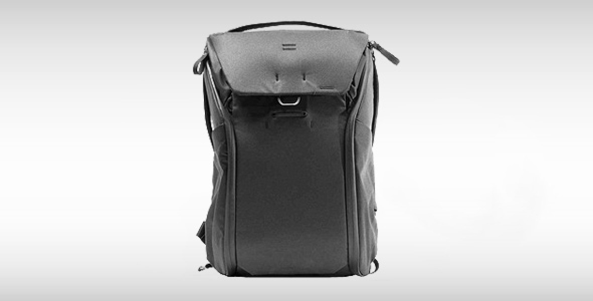 Schwarzer Rucksack mit Rolltop und Schnallenverschluss, isoliert auf weißem Hintergrund.